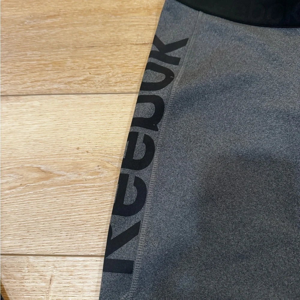 Reebok charcoal gray athletic leggings, mesh patterned detailing on side, S.
